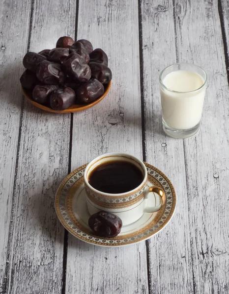Coffee with dates and a glass of milk on a white wooden table — Stock Photo, Image