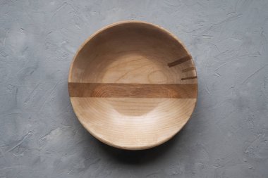 Gri bir arka plan üzerinde boş ahşap kase. Üstte görüntü.