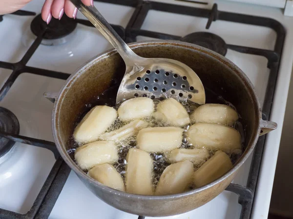 Подготовка арабского десерта Тулумба в кипящем масле. Тулумба - арабийский пропитанный сиропом жареный губчатый мед — стоковое фото