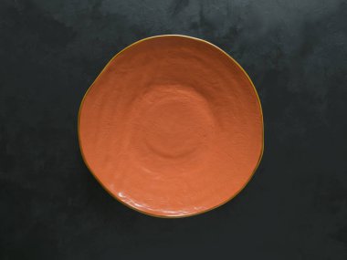 Siyah arka plan üzerine el yapımı turuncu seramik levha.