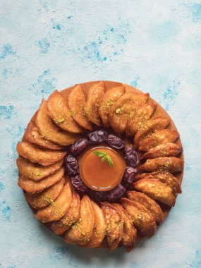 Arap Tatlıları. Arap Qatayef mavi masada tatlı peynir ve fındık ile doldurulmuş pancake.