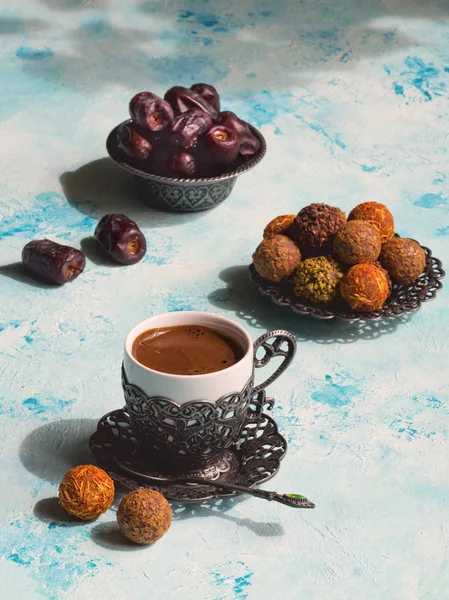 Een kopje Turkse koffie met Arabische zoetigheden met dadels op een blauwe tafel — Stockfoto