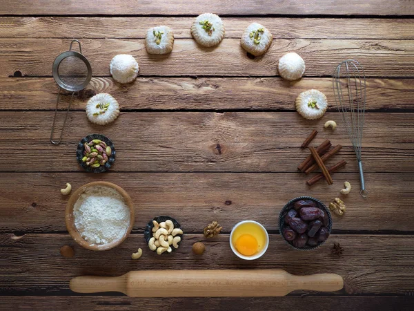 Sweets background. Egg, flour and nuts are laid out on a dark wooden background
