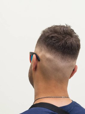 Kafasının düzgün bir şekilde kesilmiş arkası olan genç bir adam..