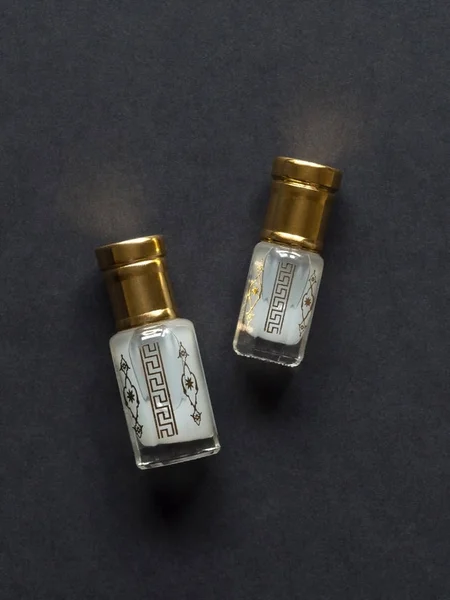 Skoncentrowane perfumy w mini butelce na czarnym stole — Zdjęcie stockowe