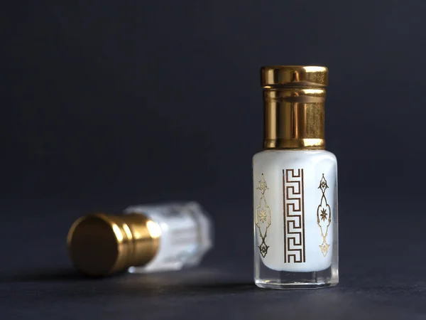Perfume concentrado en una mini botella sobre la mesa negra — Foto de Stock