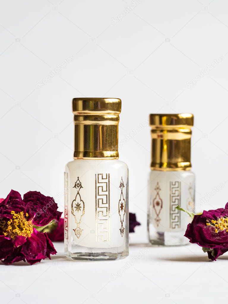 Concentrated perfume in a mini bottle on the white background