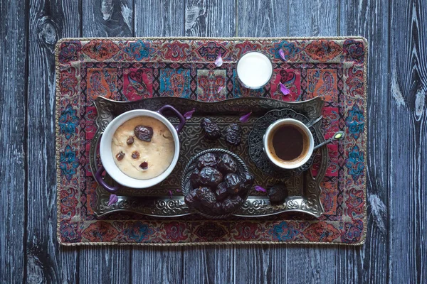 Ramadan eten. Gerst PAP met dadels en een kopje koffie op de zwarte tafel. — Stockfoto