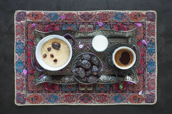 Gerst PAP met dadels en een kopje koffie op de zwarte tafel. Ramadan eten — Stockfoto