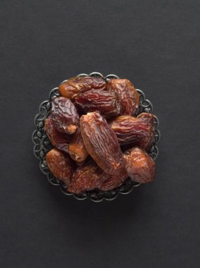 Medjool Al-Madina karanlık bir masada meyve tarihler. 