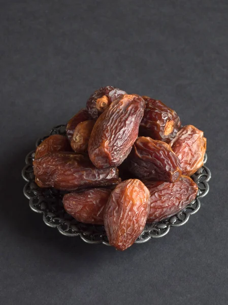 Medjool Al-Madina dates fruits on a dark table