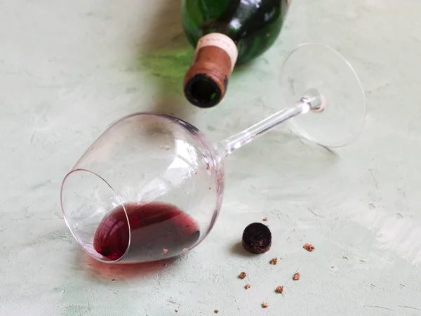 Una copa de vino viejo, una botella y un corcho roto se colocan sobre la mesa — Foto de Stock