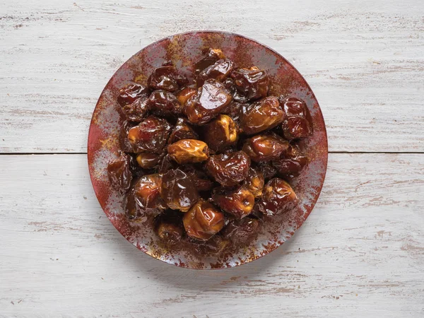 Delicious organic sweet dates in bowl with syrup. — Stock Photo, Image