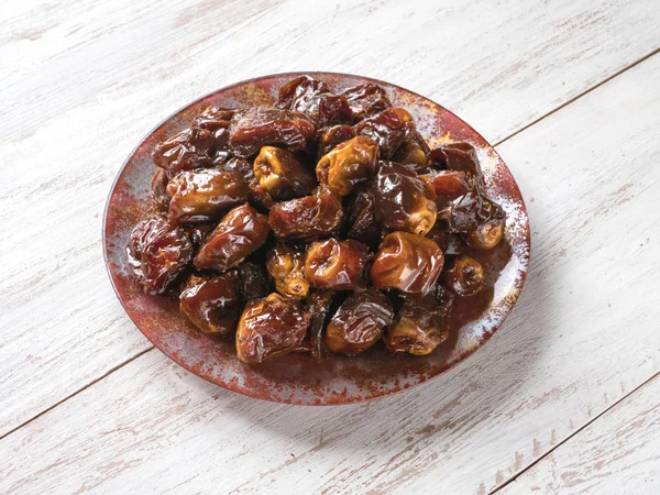 Delicious organic sweet dates in bowl with syrup.