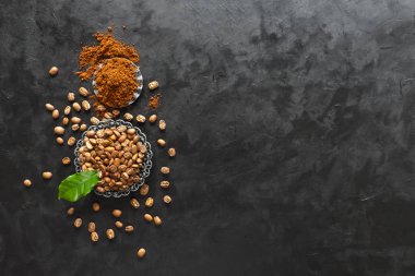 Kahve çekirdekleri ve zemin tozu siyah arka plan üzerinde. Kopyalama alanı ile üstte görünüm