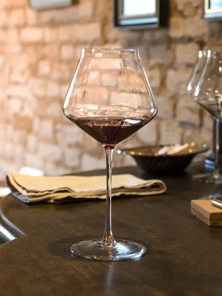 Una copa de vino tinto vintage se encuentra en el pecho de madera —  Fotos de Stock