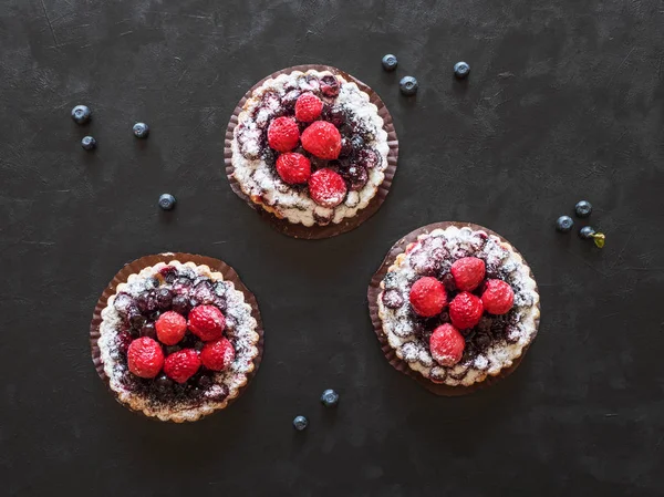 Tarts, colorful pastry cakes sweets on black — Stock Photo, Image