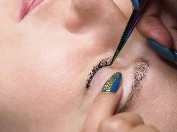 The procedure of lamination of the eyelashes. Eyelashes with tweezers