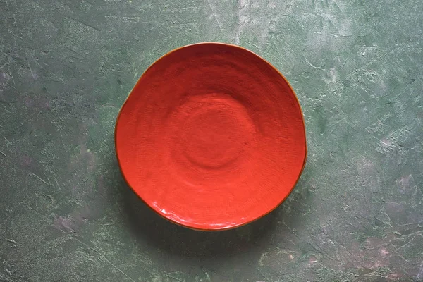 Assiette en céramique orange faite à la main sur un fond en nacre — Photo