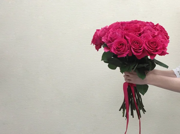 Csokor vörös rózsa a nők kezében. — Stock Fotó
