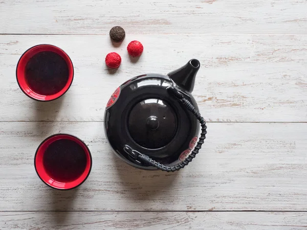 Tazas de té rojo y tetera negra en la mesa de madera — Foto de Stock