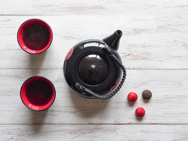 Tazas de té rojo y tetera negra en la mesa de madera — Foto de Stock