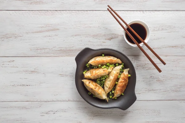 Ahşap arka planda kase kızarmış Asya köfte.