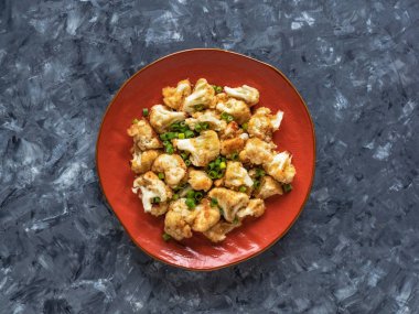 Turuncu bir tabakta kızarmış karnabahar parçaları.. 