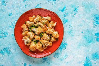 Turuncu bir tabakta kızarmış karnabahar parçaları.. 