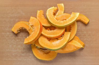 Sarı arka planda ham olgun balkabağı parçaları..