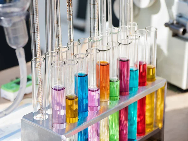 Tubos de ensayo con reactivos coloreados en un bastidor — Foto de Stock