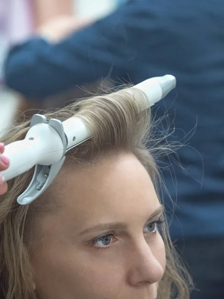 Coiffeur créer l'image de la mariée blonde . — Photo