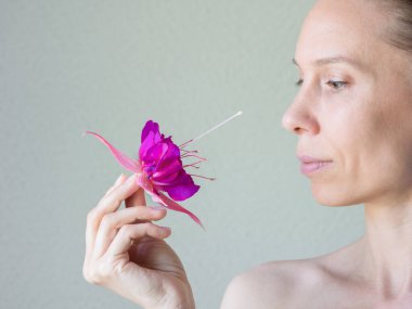 Elinde çiçekle 40 'larında çekici bir kadın.