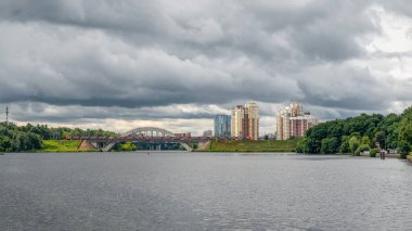 Trenli demiryolu köprüsü. Yeşil bir tepede yeni yüksek binalar. Khimki Bölgesi, Moskova