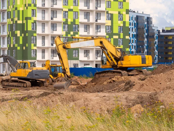 Excavadora cava el suelo para la fundación y construcción de nuevos edificios —  Fotos de Stock