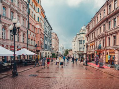 Moskova - 31 Temmuz 2020: Yağmurdan sonraki güneşli bir yaz gününde yürüyen turistlerle Arbat Caddesi.