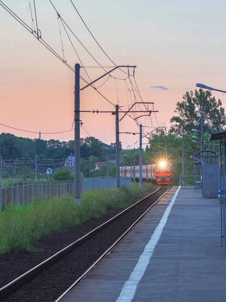 The train arrives at the village station platform in the evening — Stock Photo, Image