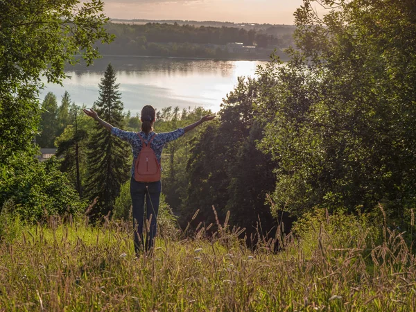 Jong meisje met een rugzak, handen spreidend van vreugde en inspiratie naar de zon gericht. Vrijheid — Stockfoto