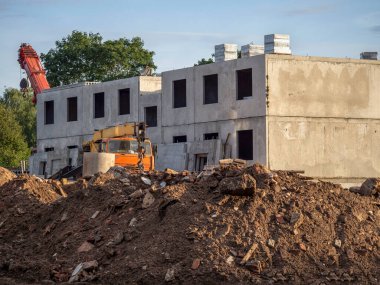 Turna bitmemiş bir binanın arka planında bir inşaat alanında.