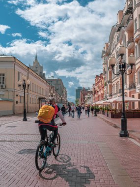 Moskova - 31 Temmuz 2020: Sırt çantalı bir bisikletçi Moskova 'daki Arbat Caddesi boyunca ilerliyor.