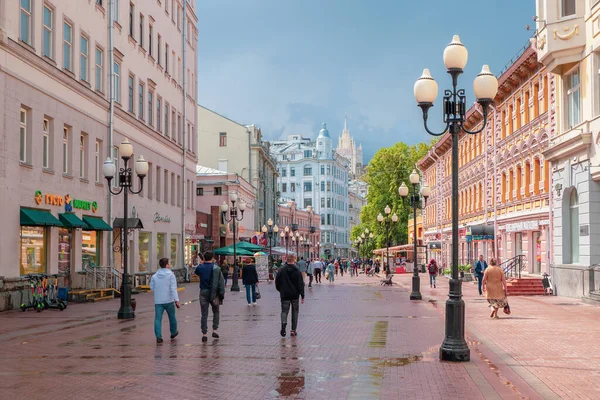 Moskova - 31 Temmuz 2020: Yağmurdan sonraki güneşli bir yaz gününde yürüyen turistlerle birlikte Arbat Caddesi. Arbat Caddesi - Moskova 'nın ana turistik merkezlerinden biri, dükkanlar ve restoranlarla dolu..