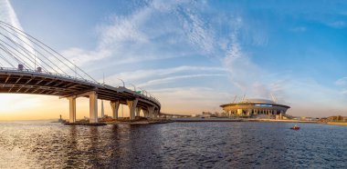 Rusya, Saint Petersburg, 25 Eylül 2020. Zenith futbol stadyumunun panoramik manzarası, günbatımında kablo destekli köprü ve otoyol..