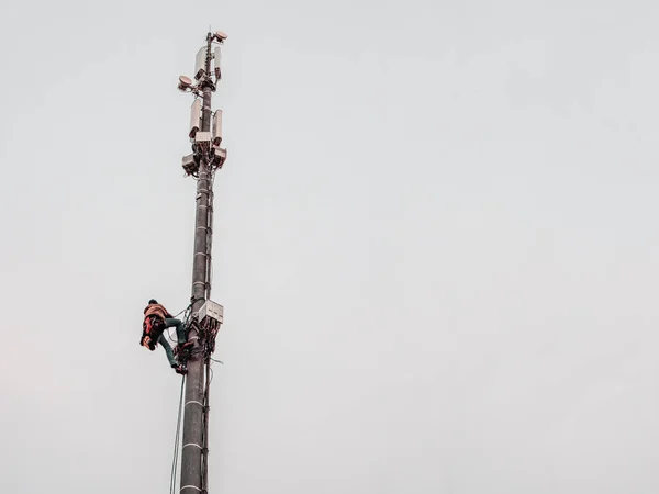 Un travailleur de grande hauteur travaille sur une tour de téléphonie cellulaire — Photo