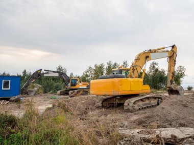 Kazıcı yeni bir binanın temelleri ve inşaatı için zemin kazıyor.