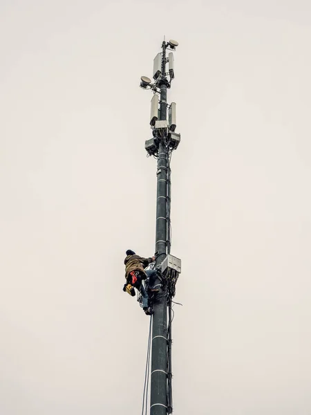 Высотный рабочий работает на вышке сотовой связи — стоковое фото