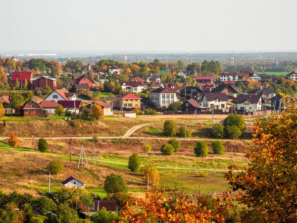 Sunny autumn rural landscape with houses in the distance. — Stock Photo, Image