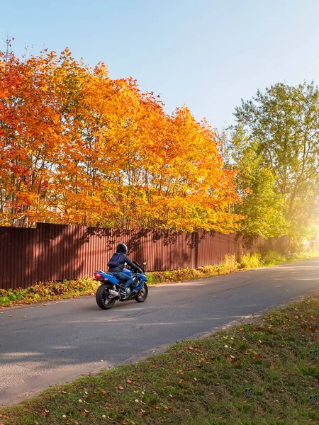 Biker sepeda motor biru lalu lintas di jalan pedesaan musim gugur. — Stok Foto