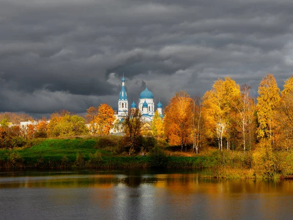 Catedral branca à distância cercada por árvores douradas de outono — Fotografia de Stock