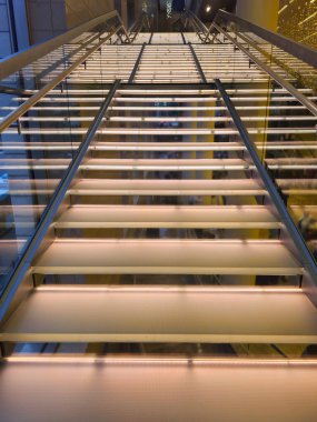 Modern bir iç mekanda aydınlatılmış basamaklı merdiven. Dipteki manzara. Oteldeki parlak merdiven. Dikey görünüm.