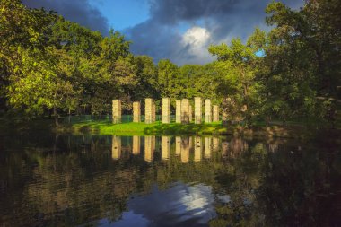 Admiralty, ruins. Park structure in the Palace Park, Gatchina. Weekend walks in the evening park. The lake is surrounded by trees with green foliage. It's a beautiful park on a sunny autumn day.